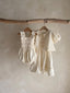 Baby meisje Diana romper van stevig katoen met gesmokt bovenlijfje - Creme (3 - 18 maanden) samen met june dress creme vooraanzicht